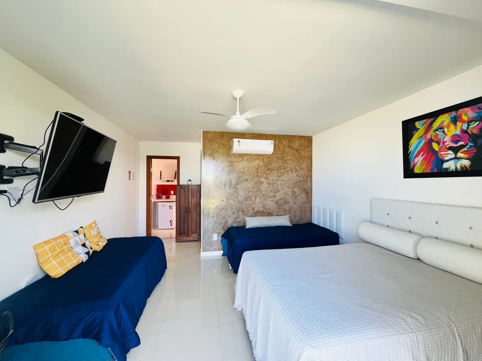 Quarto amplo com cama de casal, camas auxiliares, TV e ar-condicionado